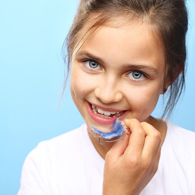 Young girl placing and orthodontic appliance