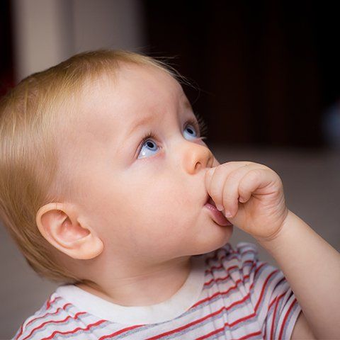 Child sucking thumb before thumb crib placement