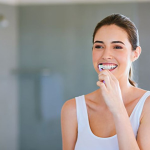 Young woman brushing her teeth in bathroom