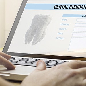 Person filling out dental insurance form on laptop