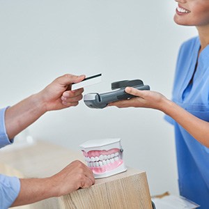 Dental team member accepting payment from patient
