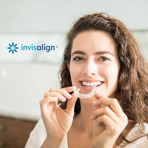 Woman placing Invisalign® clear aligner tray
