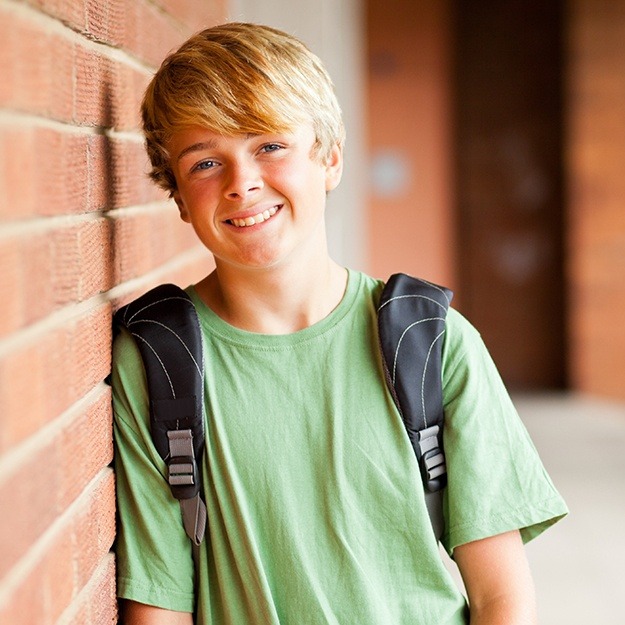 Preteen boy sharing healthy smile after dentofacial orthopedics