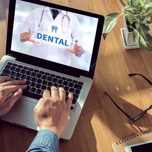 Man using computer to learn more about dental insurance coverage