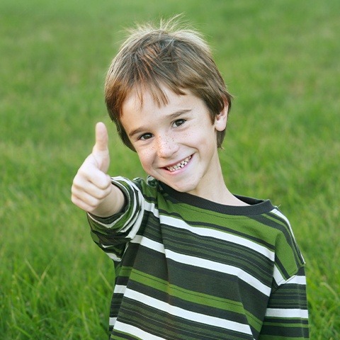 Little boy smiling and giving thumbs up after phase one orthodontics visit