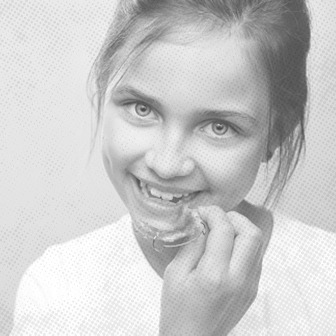 Young girl placing an orthodontic appliance