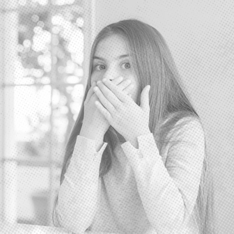 Young woman experiencing orthodontic emergency covering her mouth