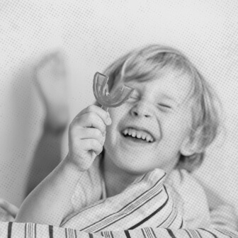 Child holding up phase one orthodontic mouth guard