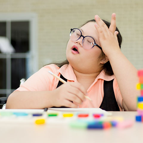 Young girl with sensory processing issues holding her head