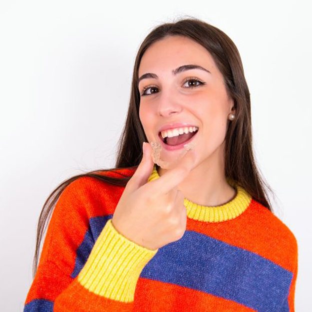 Teen girl holding SureSmile clear aligner