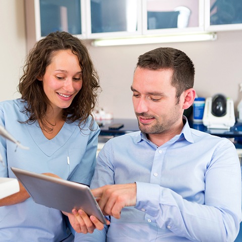 Patient and orthodontic team member looking at tablet