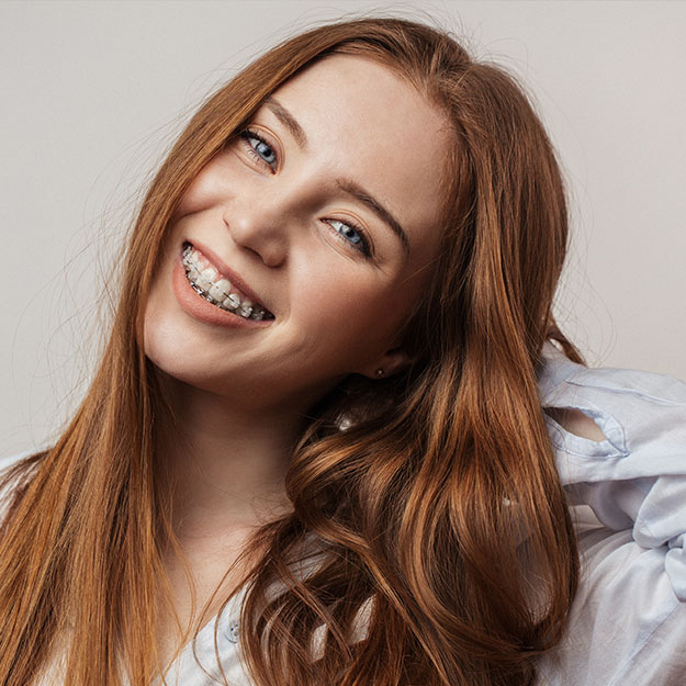 Young woman with traditional braces smiling