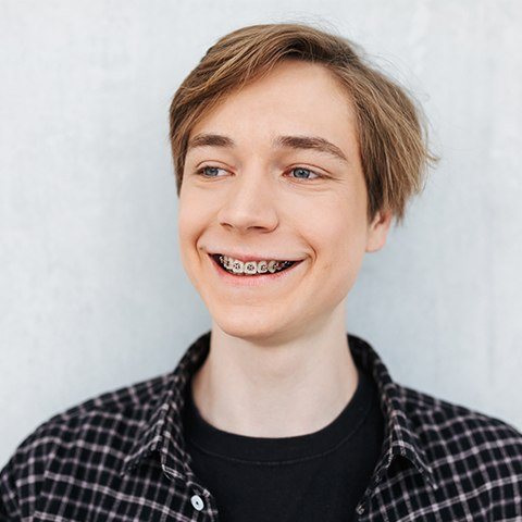 Teen boy with phase one orthodntics appliance in place smiling