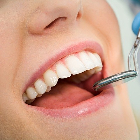 Orthodontist examining patient's smile after laser gum recontouring