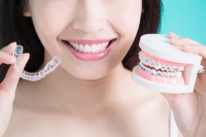 Smiling woman comparing clear aligners vs traditional braces