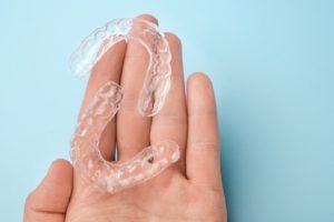 Close-up of hand holding two clear orthodontic aligners