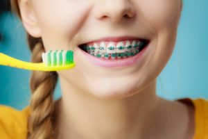 girl brushing with braces