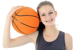 Teen girl with braces, holding basketball