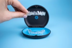 a person holding an Invisalign aligner