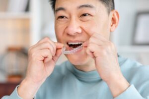 Man putting in Invisalign aligners