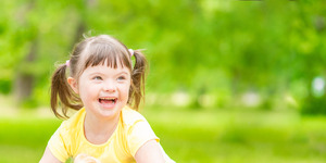 Little girl with special needs smiling in a field