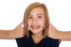Young patient smiling with orthodontic headgear