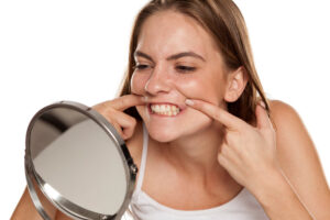 Patient checking teeth in mirror after using old retainer